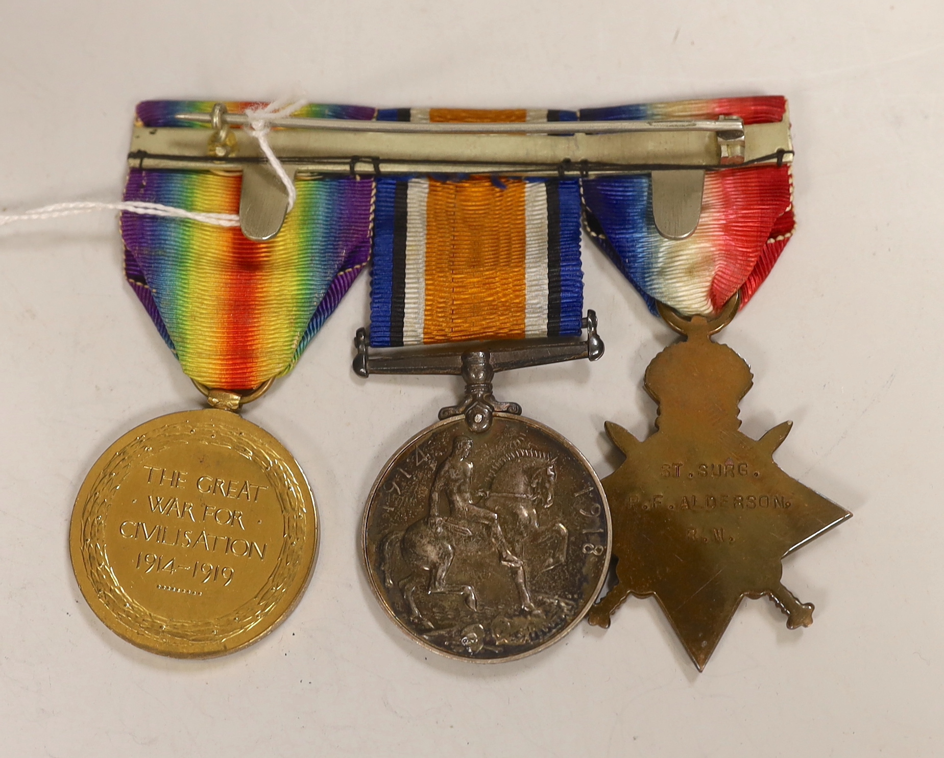 A WWI trio to St. Surgeon Commander P.F. Alderson R.N., comprising 1914 Star, British War Medal and Victory Medal, mounted on pin brooch